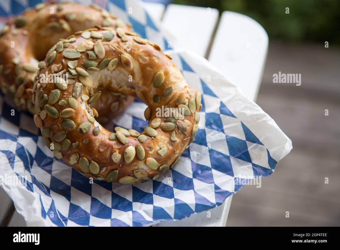 Pretzel bavaresi freschi per colazione, adagiati su un tavolo di legno all'aperto Foto Stock