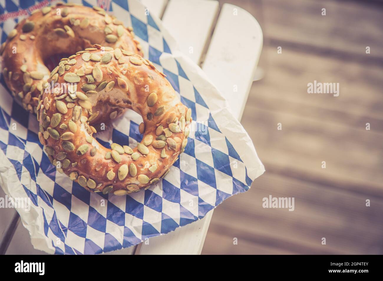 Pretzel bavaresi freschi per colazione, adagiati su un tavolo di legno all'aperto Foto Stock