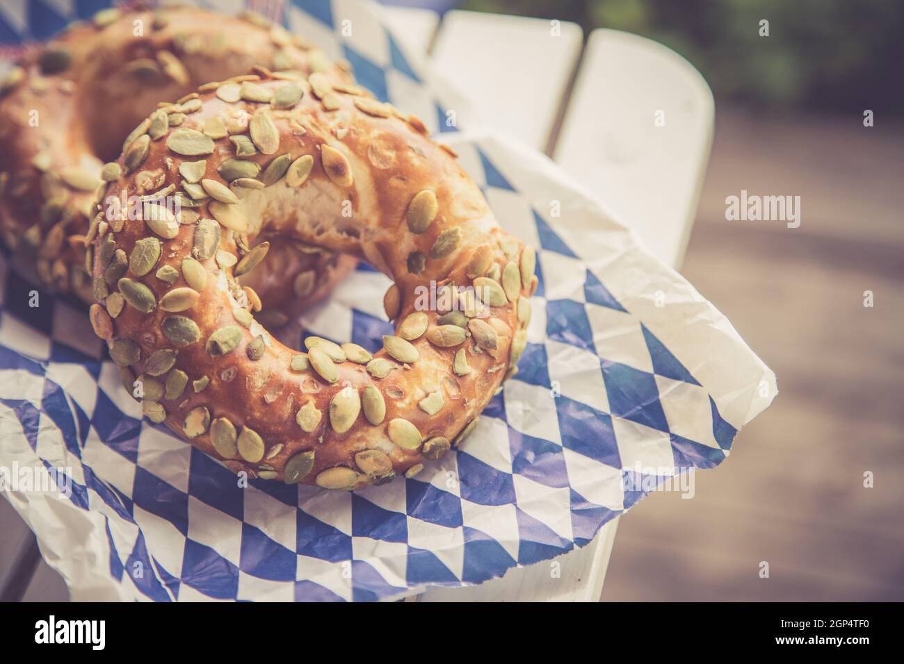 Pretzel bavaresi freschi per colazione, adagiati su un tavolo di legno all'aperto Foto Stock