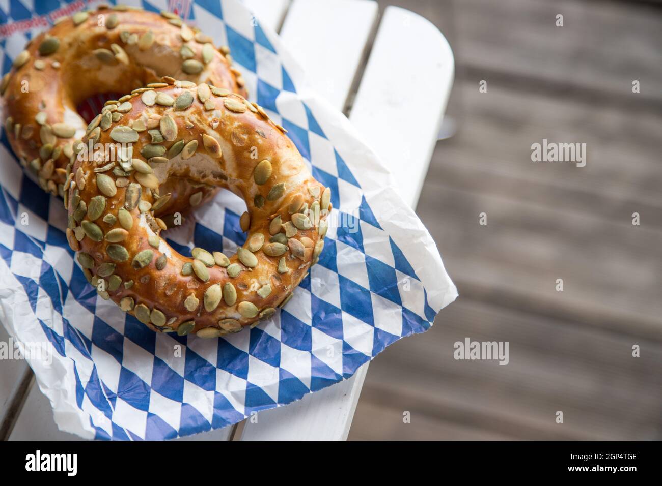 Pretzel bavaresi freschi per colazione, adagiati su un tavolo di legno all'aperto Foto Stock