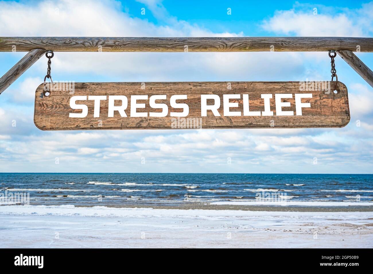 Stress sollievo segno di legno contro cielo blu e mare con le onde. Foto Stock