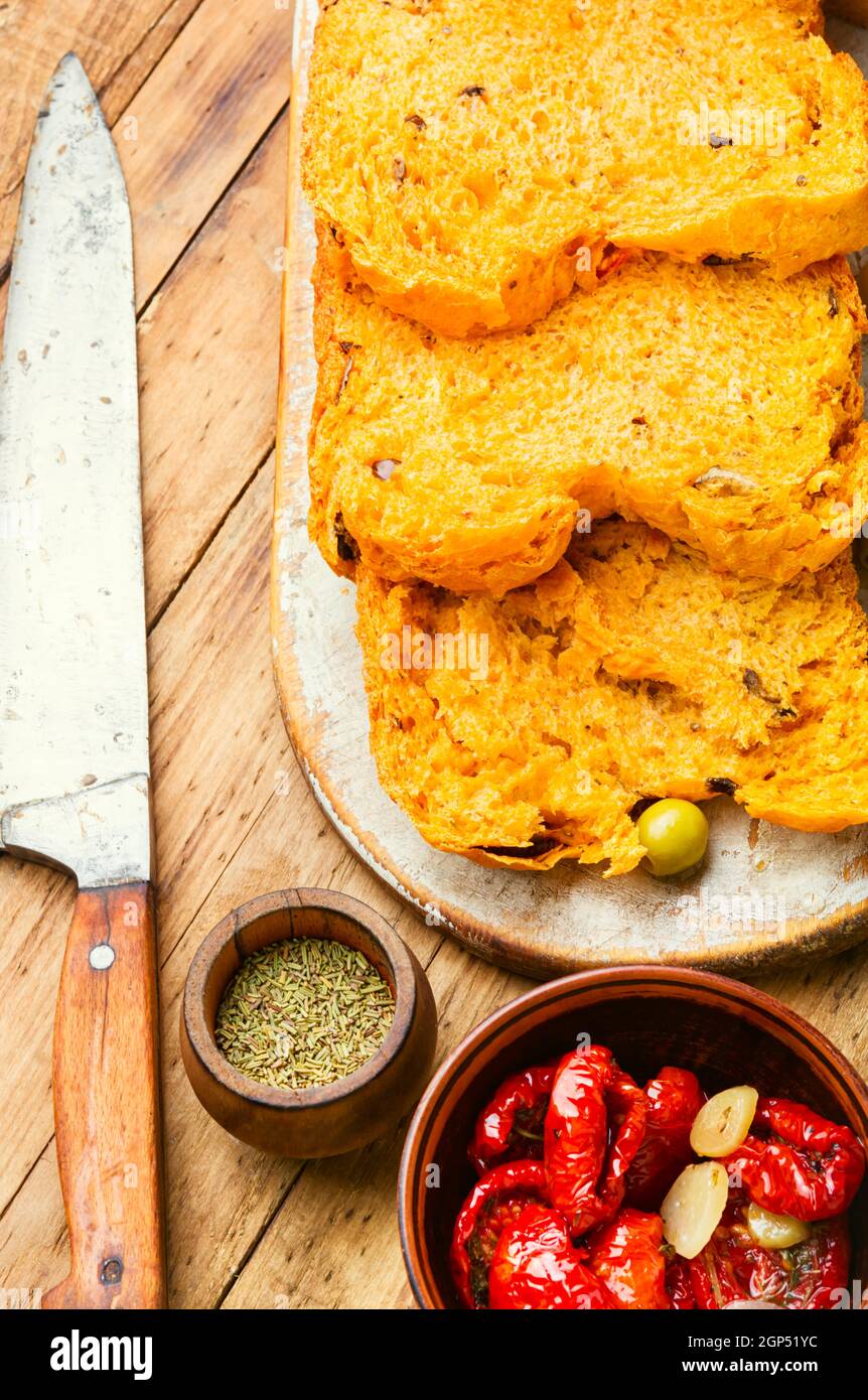 Pane fatto in casa a fette con pomodori secchi su pane di legno table.Olive Foto Stock