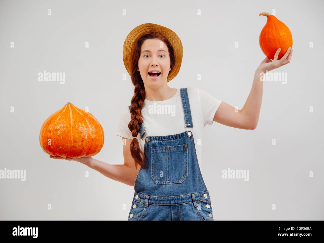 Donna di agricoltura pesa con le mani una piccola e grande zucca organica. Foto Stock