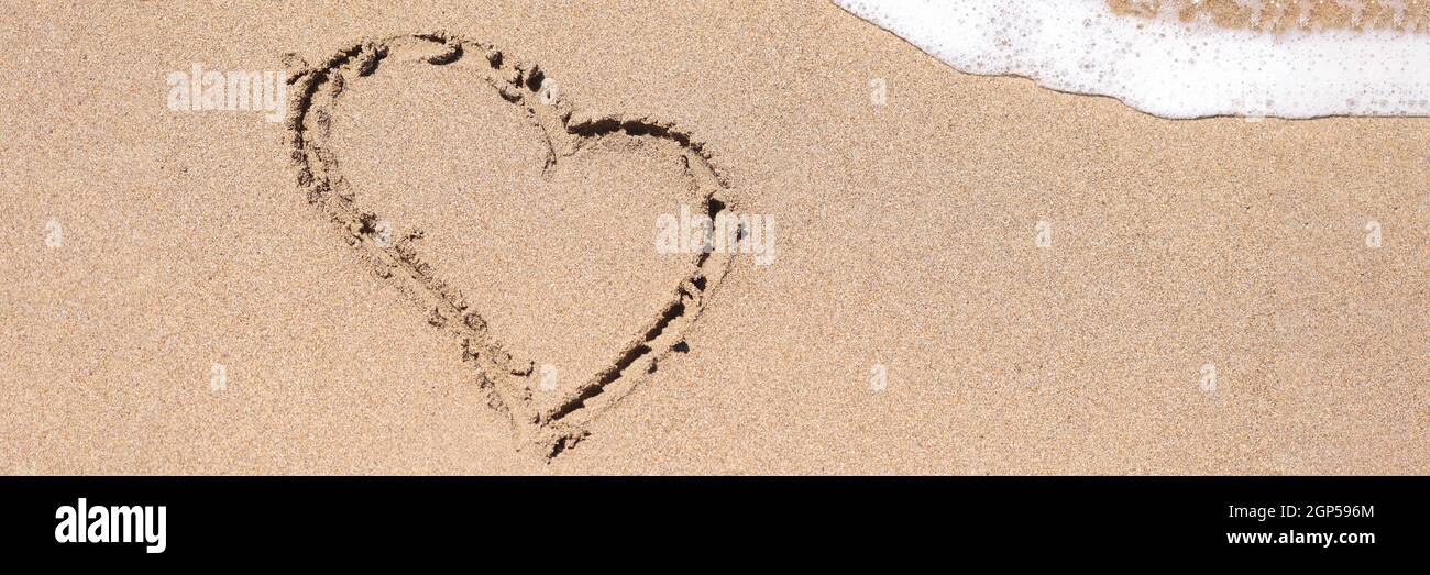 Disegnato cuore su sabbia bagnata accanto al mare closeup Foto Stock