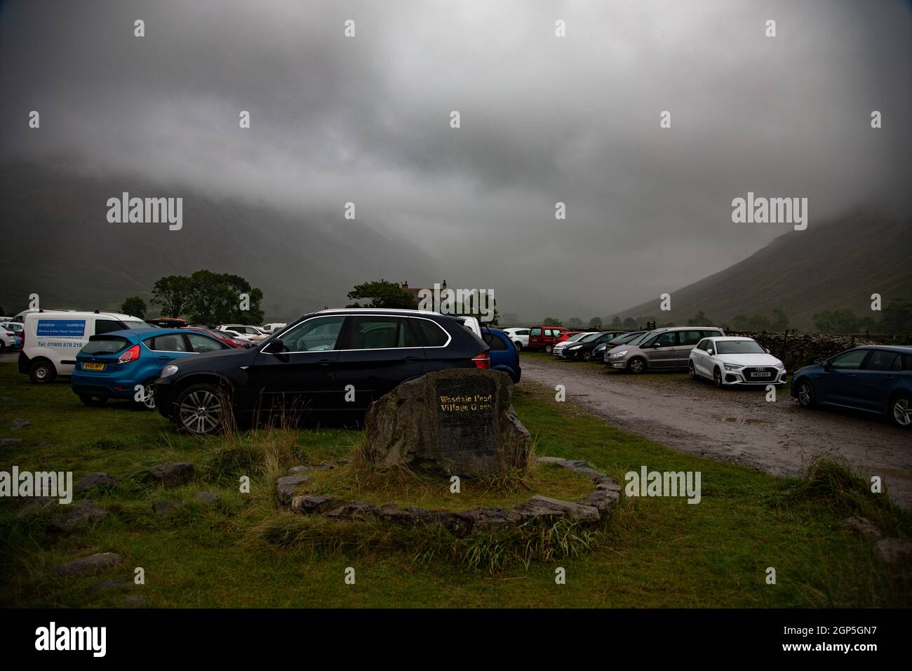 Auto parcheggiate a Wasdale Head Village Green in forte pioggia Foto Stock