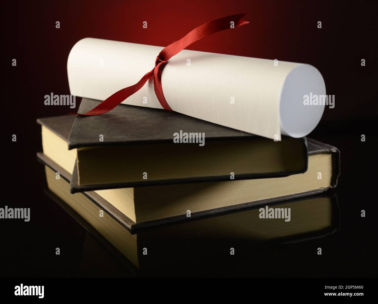 Un diploma in cima a un paio di libri mostra il successo di profitto degli studi scolastici. Foto Stock