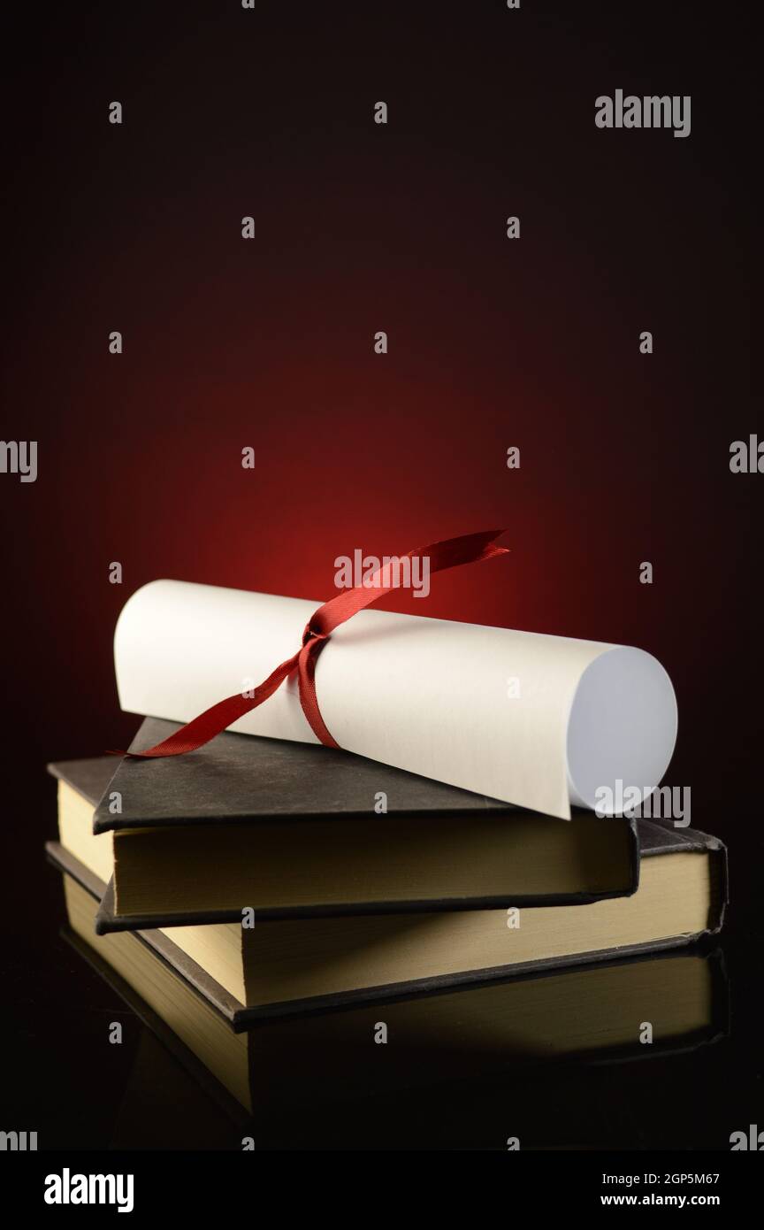 Un diploma in cima a un paio di libri mostra il successo di profitto degli studi scolastici. Foto Stock