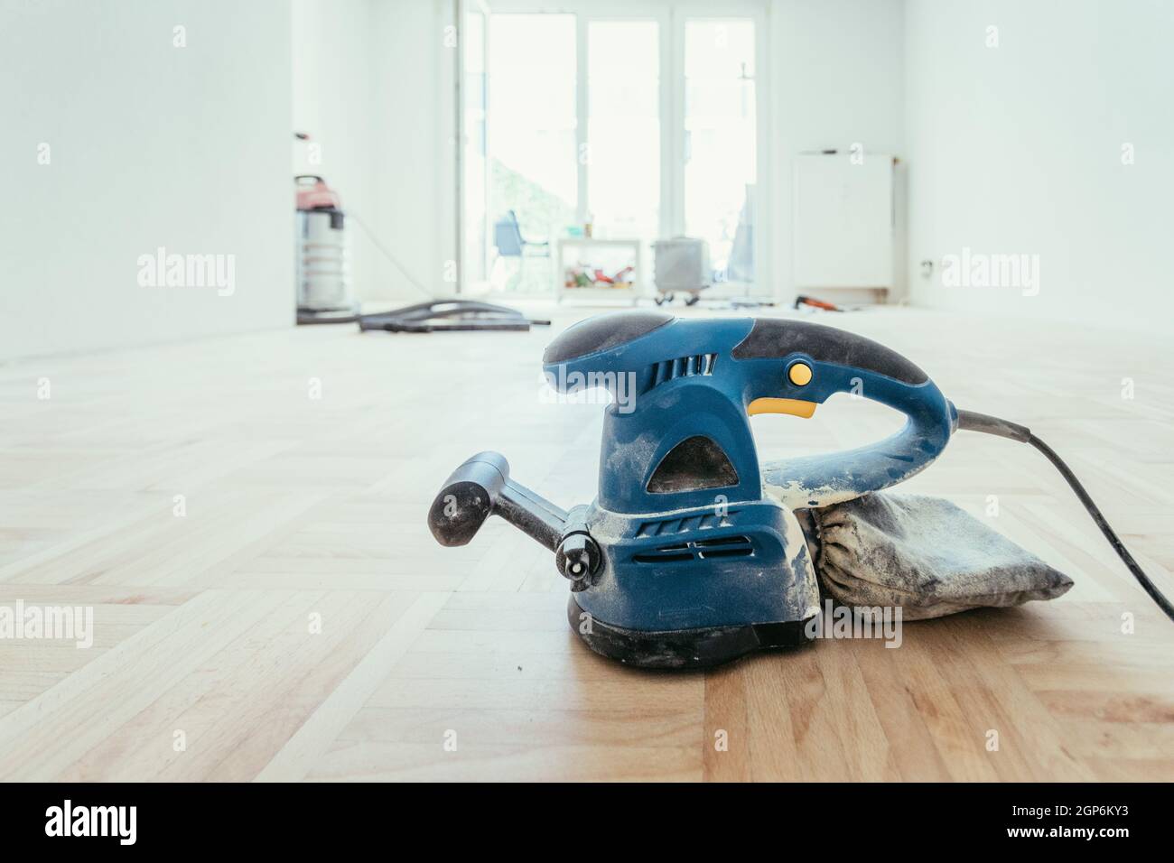 Uomo con levigatrice a pavimento su solidi e il pavimento in parquet di  legno Foto stock - Alamy