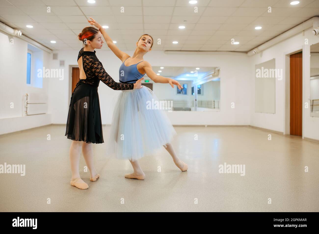 Coreografo lavora con la giovane ballerina in classe. Scuola di balletto, ballerini femminili in coreografia, ragazze che praticano la danza della grazia Foto Stock