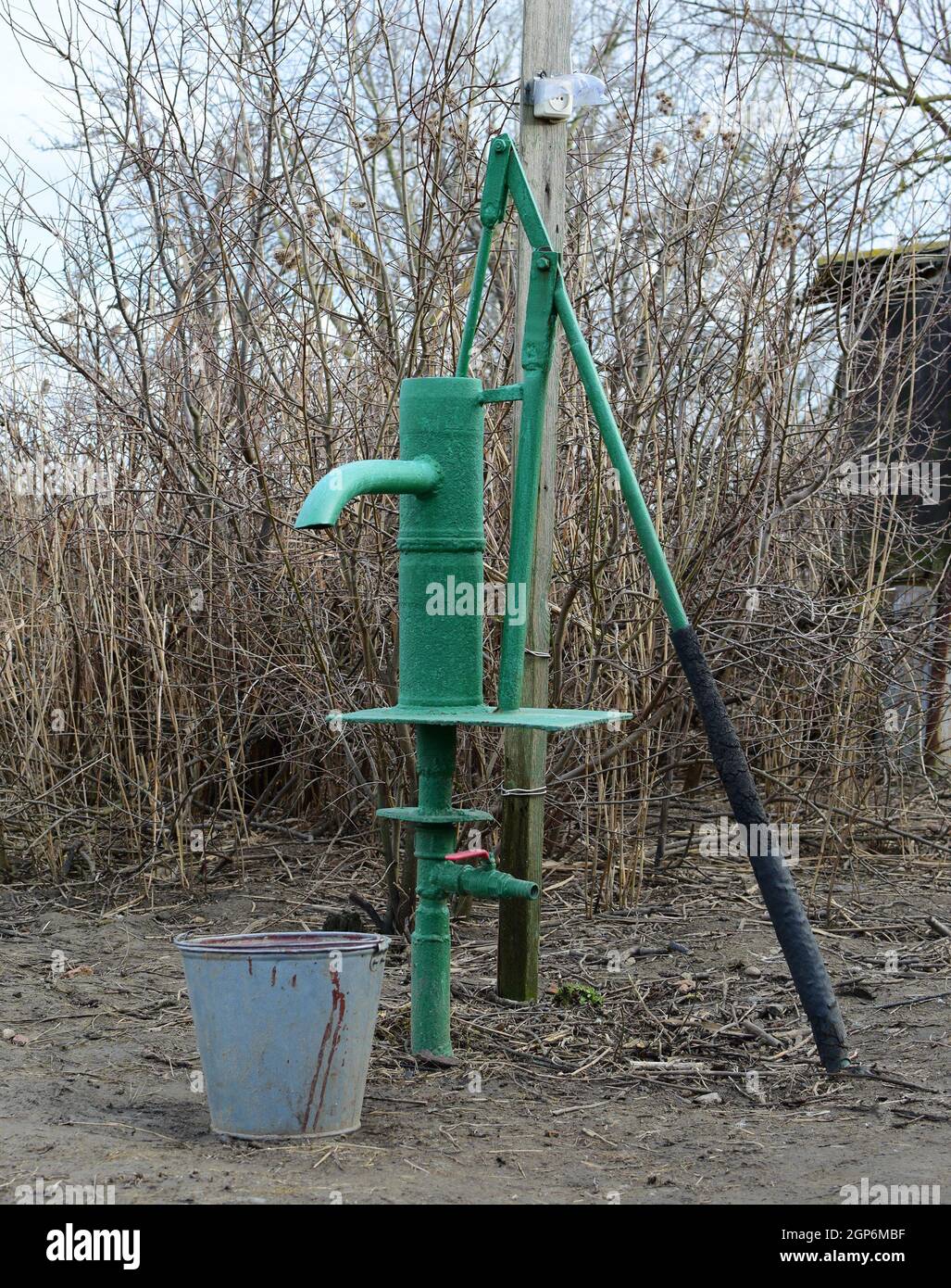 Pompa a mano portando ad un pozzo artesiano. Pompaggio di acqua per  irrigazione del giardino Foto stock - Alamy