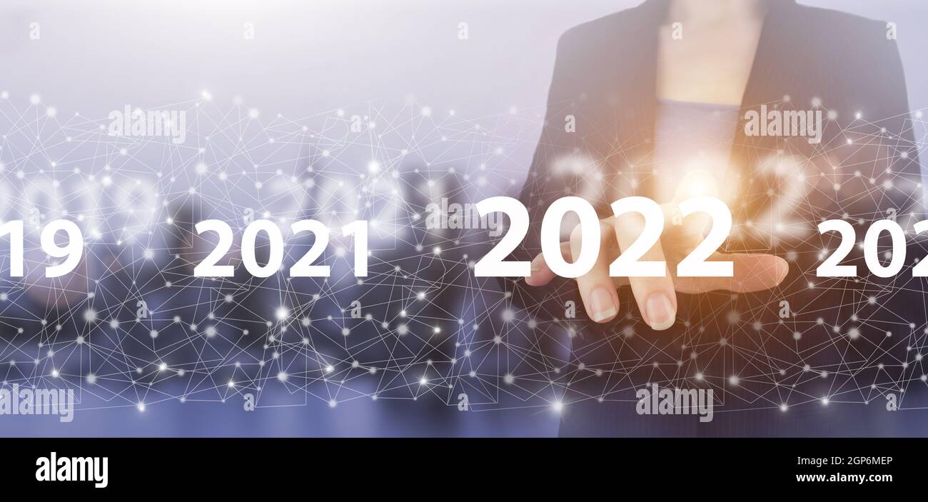 Nuovo anno 2022,obiettivo,piano,azione. Mano touch schermo digitale ologramma 2022 segno sulla città luce sfondo sfocato. Concetto di successo per il nuovo anno. Mana aziendale Foto Stock