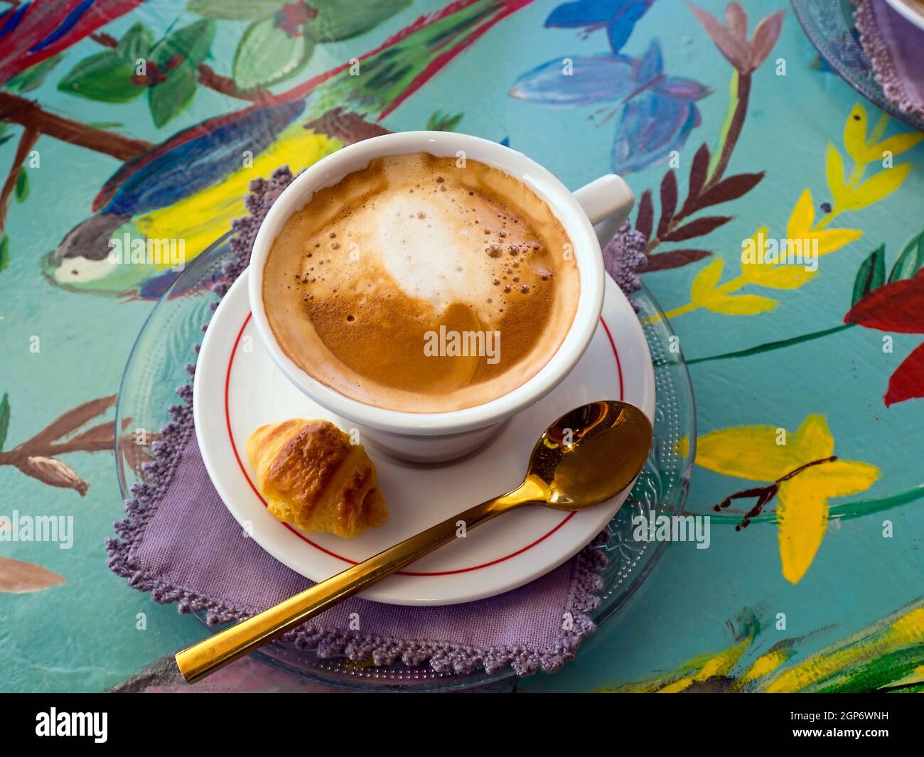 Froloso caffè al latte spagnolo su un tavolo esotico decorato, colorato, insolito e ottimista. Vita morta moderna con caffè al crepuscolo. Foto Stock