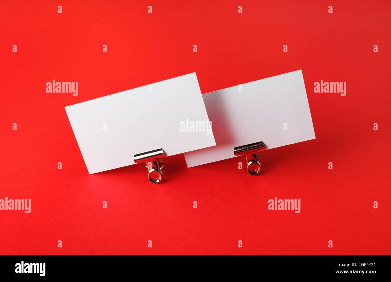 Foto di biglietti da visita vuoti su sfondo di carta rosso. Modello per ID. Foto Stock