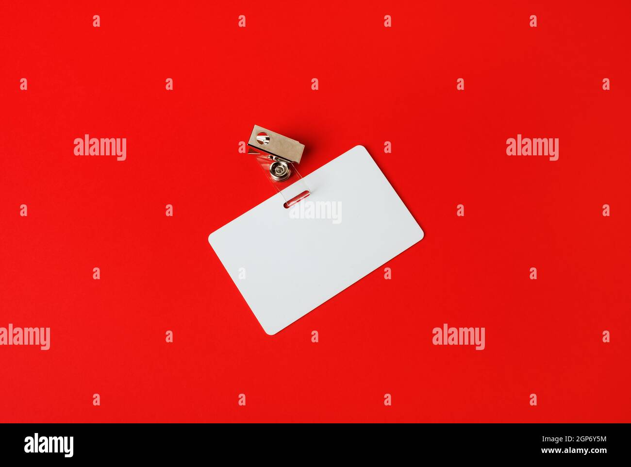 Scheda ID bianca. Badge di sicurezza vuoto su sfondo di carta rosso. Spazio di copia per il testo. Foto Stock