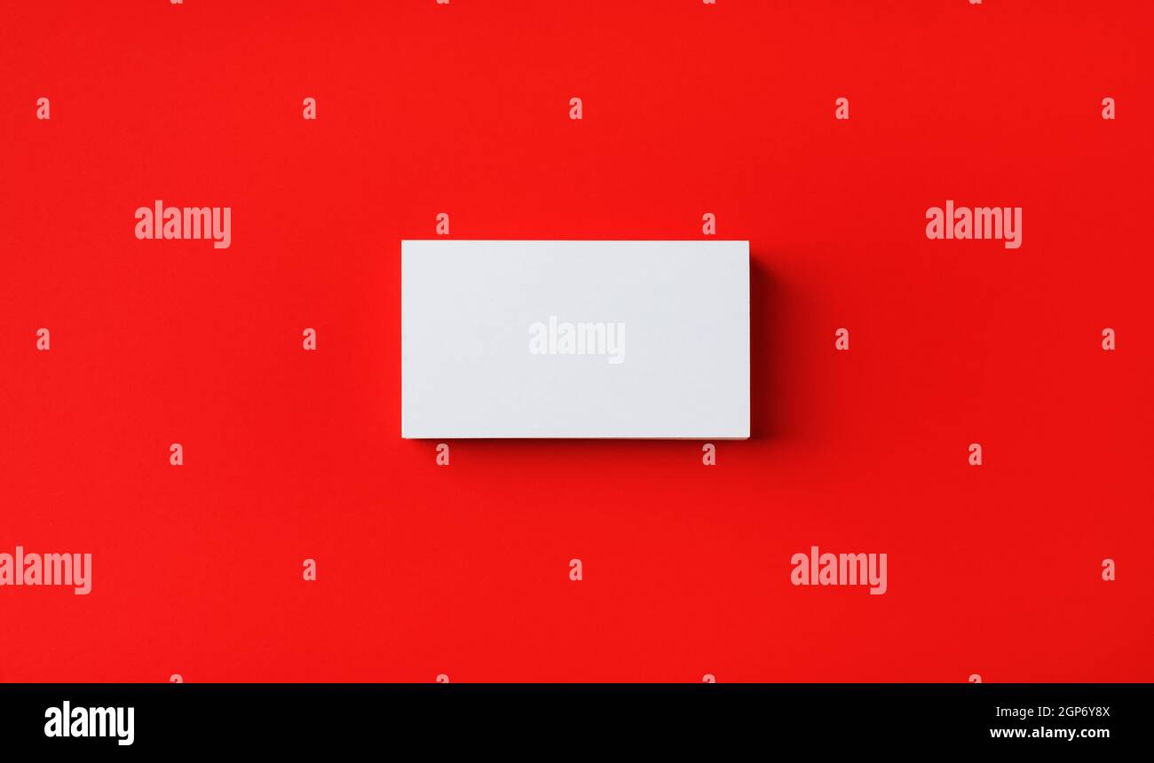 Foto del biglietto da visita vuoto su sfondo di carta rosso. Modello per identità di branding. Mockup per ID. Disposizione piatta. Foto Stock