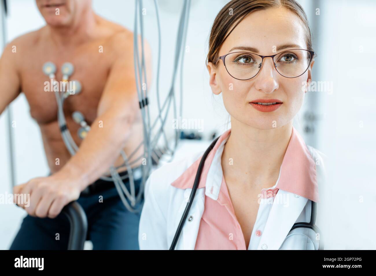 Il medico guarda lo schermo della macchina mentre il paziente ha un ECG sotto sforzo o sotto sforzo Foto Stock