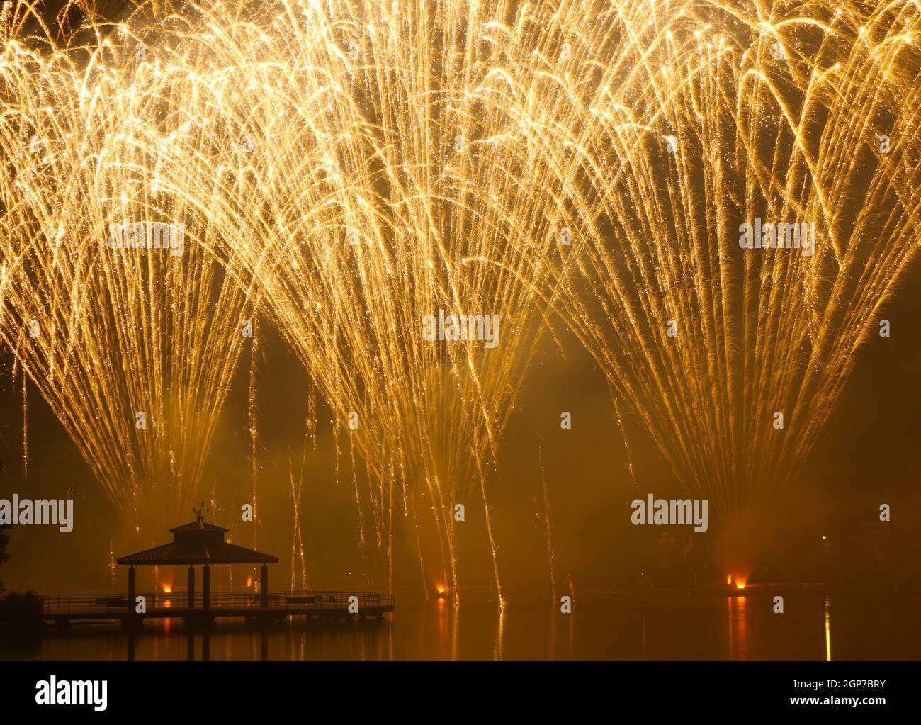Fuochi d'artificio al Delco Park. Molo di pesca e la silhouette del padiglione in primo piano dei fuochi d'artificio esposti al suolo. Delco Park, Kettering, Dayton, Ohio, Stati Uniti. Foto Stock