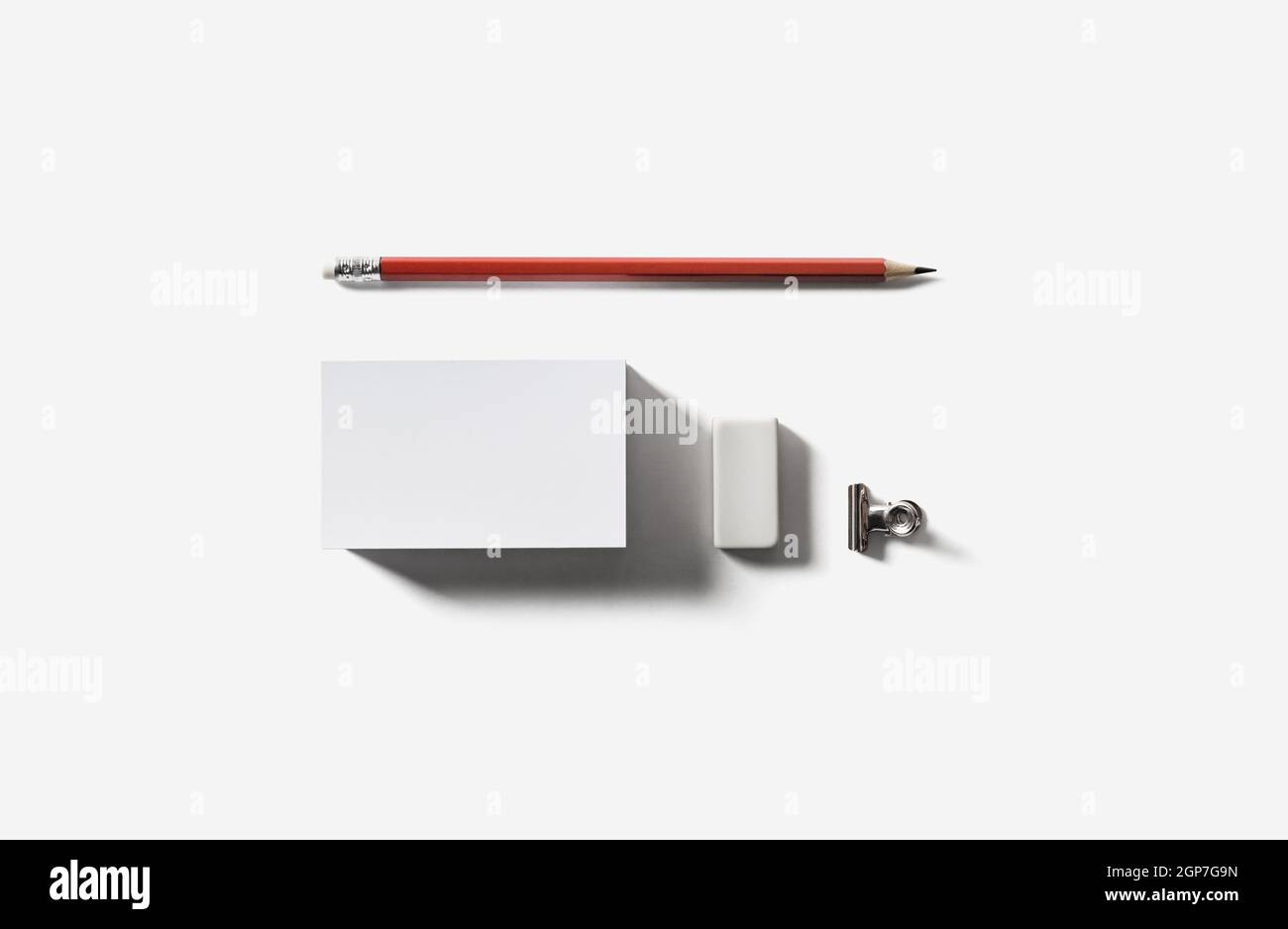 Biglietto da visita bianco vuoto, matita e gomma. Vista dall'alto. Disposizione piatta. Foto Stock