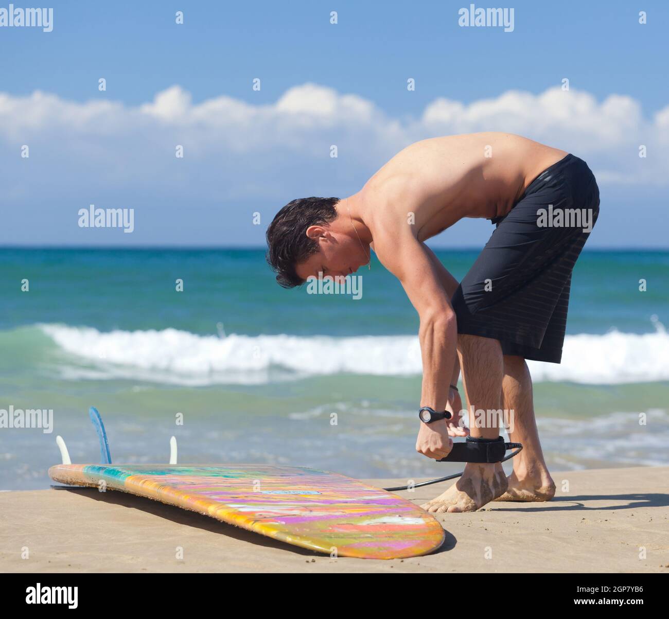 Surfer indossa guinzaglio di sicurezza alla caviglia sulla spiaggia Foto Stock