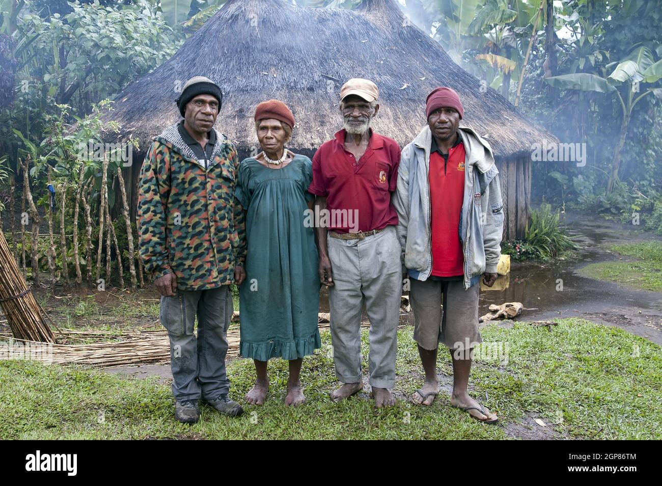 Papua Nuova Guinea; Goroka; Stazione Missionaria Cattolica di Namta (Mefenga) guidata dai Missionari della Sacra Famiglia. Un gruppo di Papuani fuori da una capanna. Foto Stock