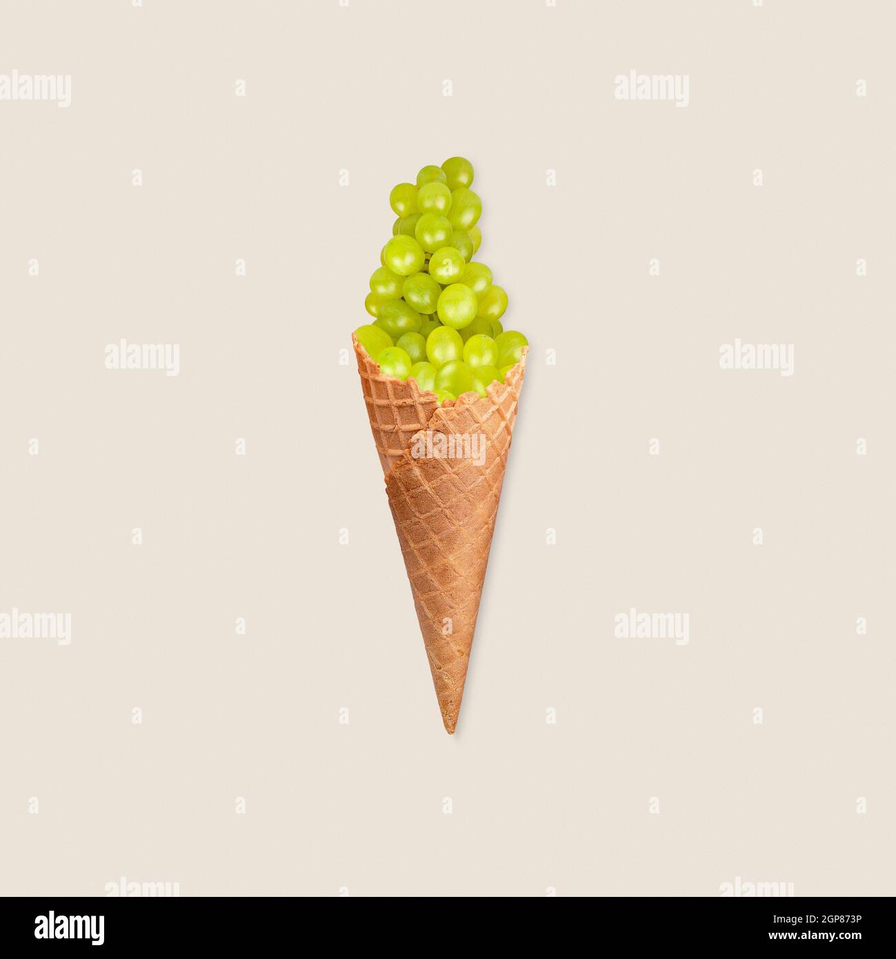 Concetto di alimentazione sana con manipolazione fotografica del gelato all'uva verde su sfondo pastello Foto Stock