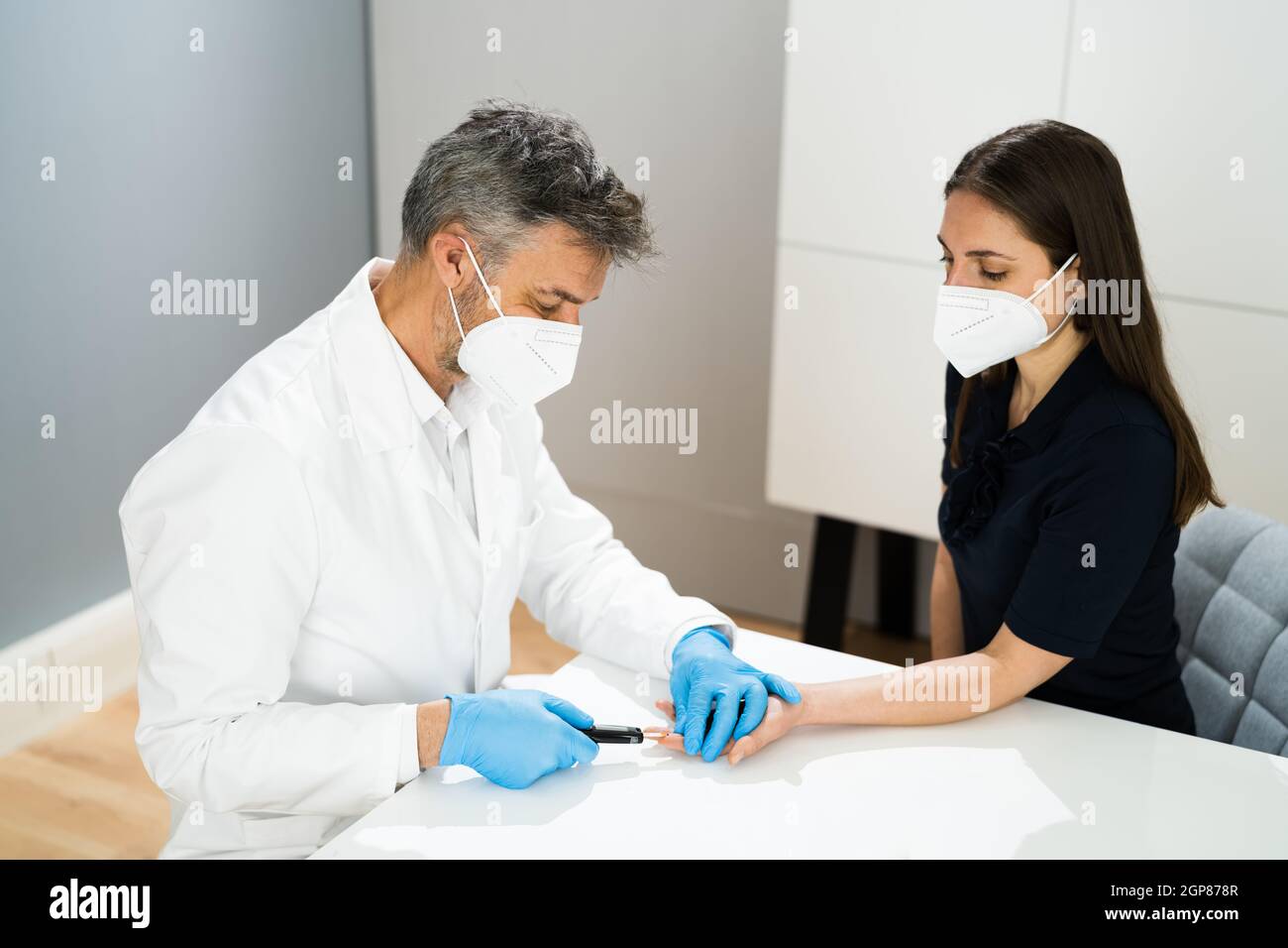 Test di zucchero nel sangue dal medico in maschera facciale Foto Stock