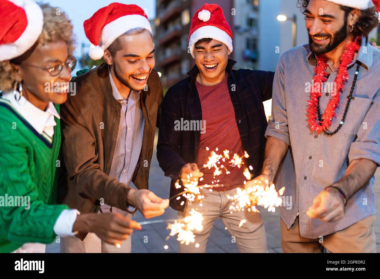 Gruppo di giovani diversi che festeggiano il natale o il Capodanno in città Foto Stock