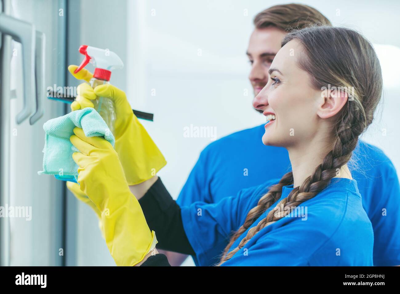 Detergenti commerciali per la pulizia di una finestra da ufficio con guanti Foto Stock