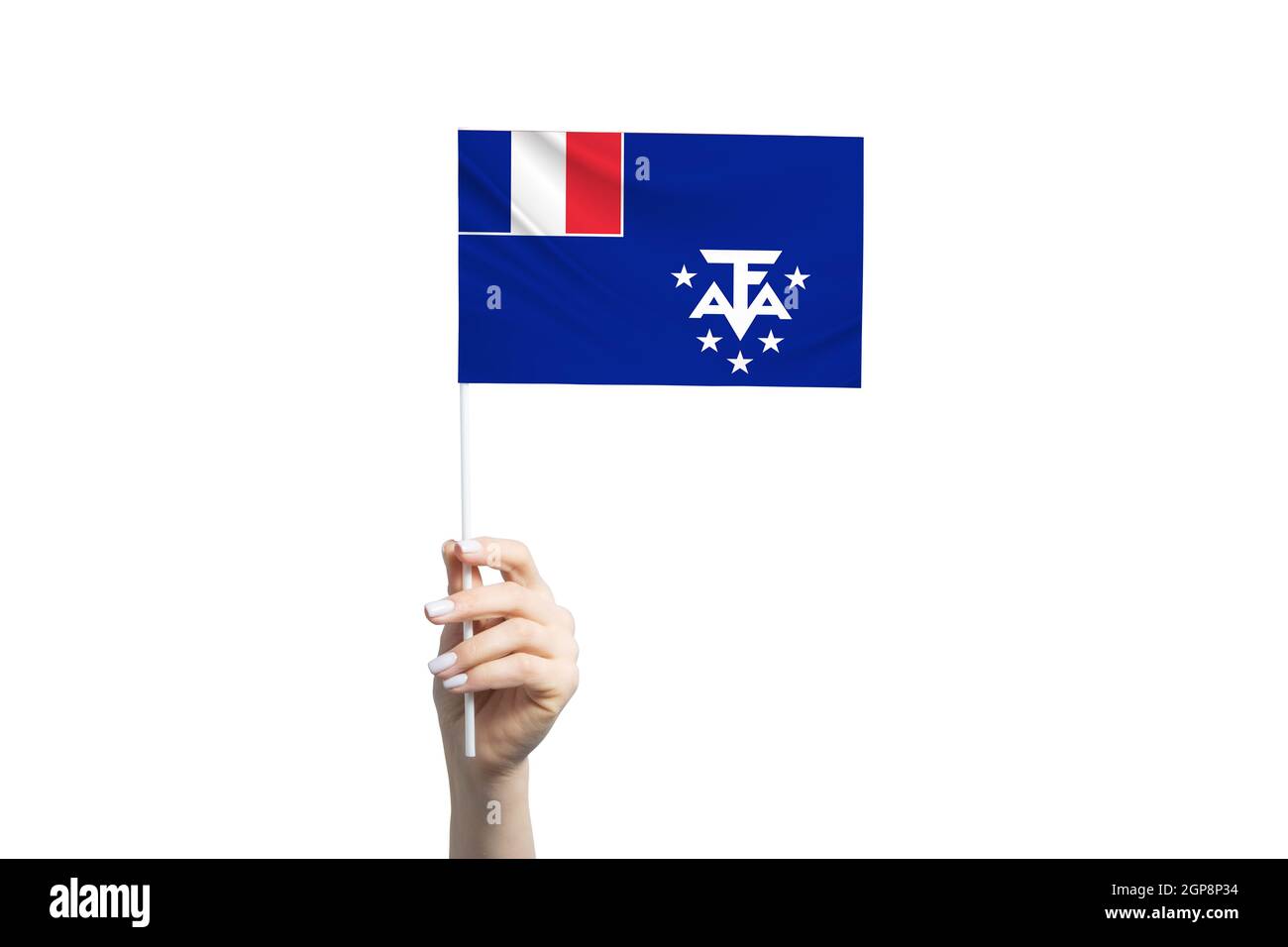 Bella mano femminile che tiene bandiera francese del Sud e Antartico territori, isolato su sfondo bianco. Foto Stock