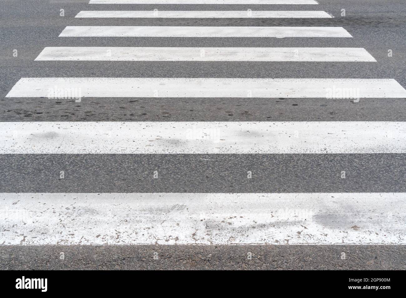 Crosswalk bianco su asfalto. La segnaletica stradale attraversamento pedonale di close-up. Foto Stock