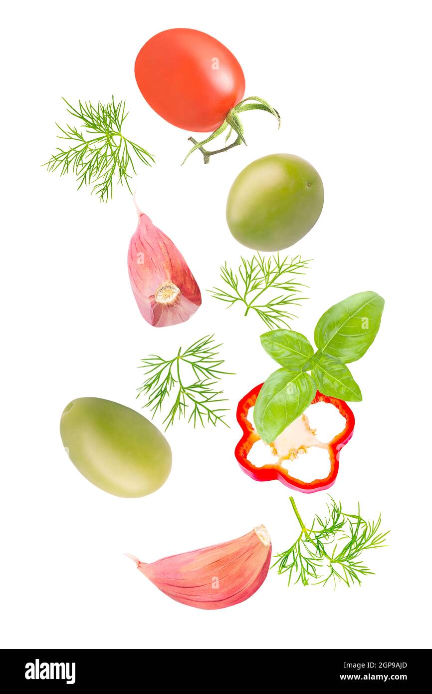Vegetali isolati. Pomodori misti, aneto, olive verdi, basilico, peperone e aglio che cadono in giù isolano su bianco con percorso di taglio come pacchetto des Foto Stock
