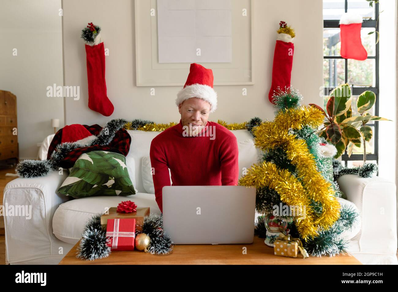 Albino african american uomo che indossa santa Hat fare videochiamata con decorazioni di natale Foto Stock