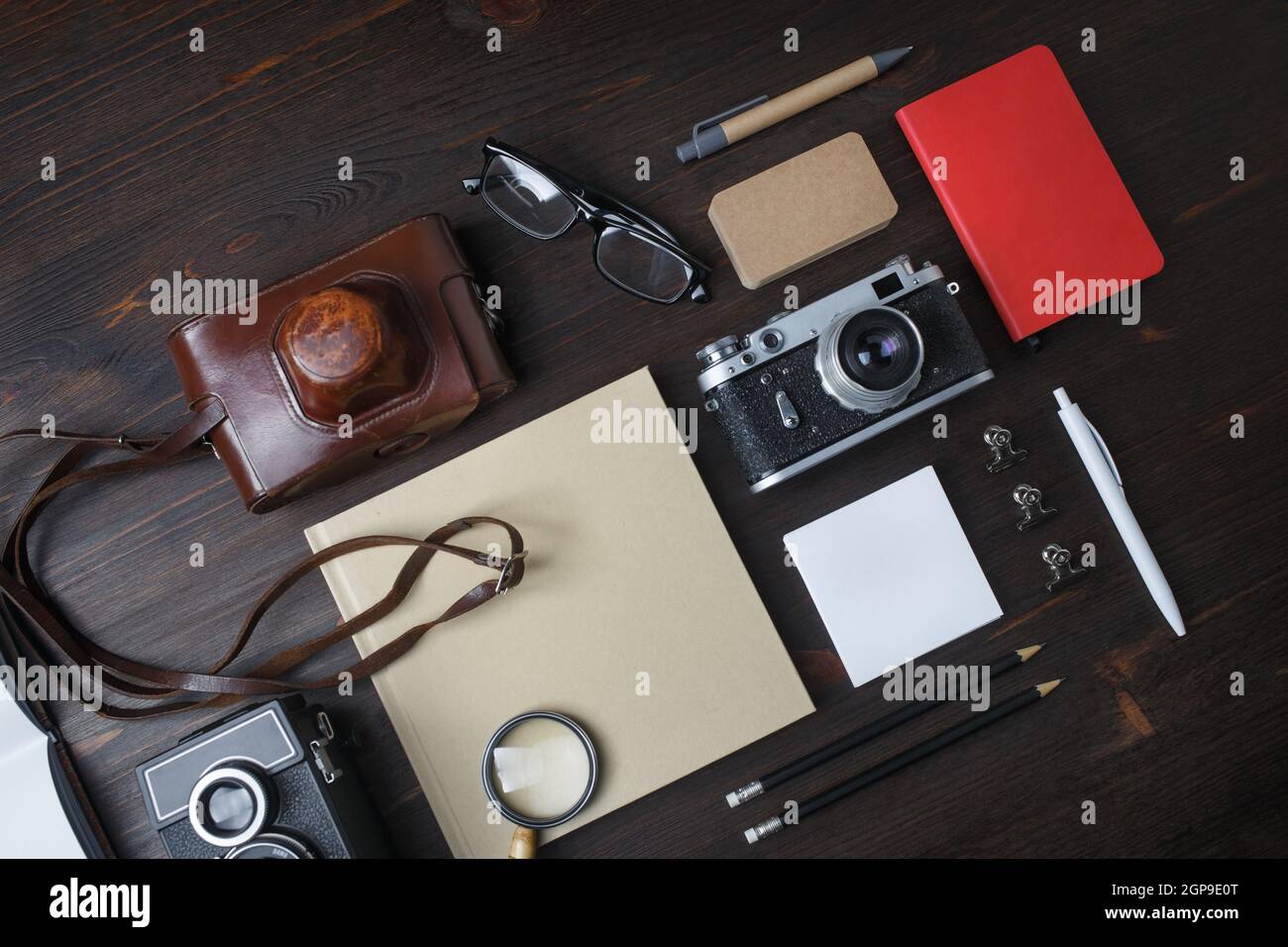 Concetto di viaggio con fotocamera retrò su sfondo in legno. Disposizione piatta. Foto Stock