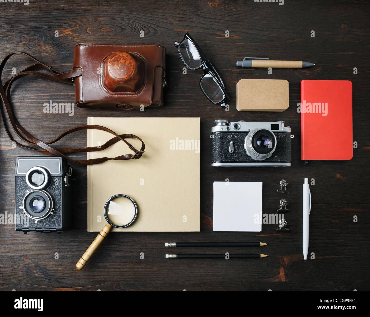 Cancelleria da viaggio e fotocamera retrò su sfondo tavolo in legno. Disposizione piatta. Foto Stock