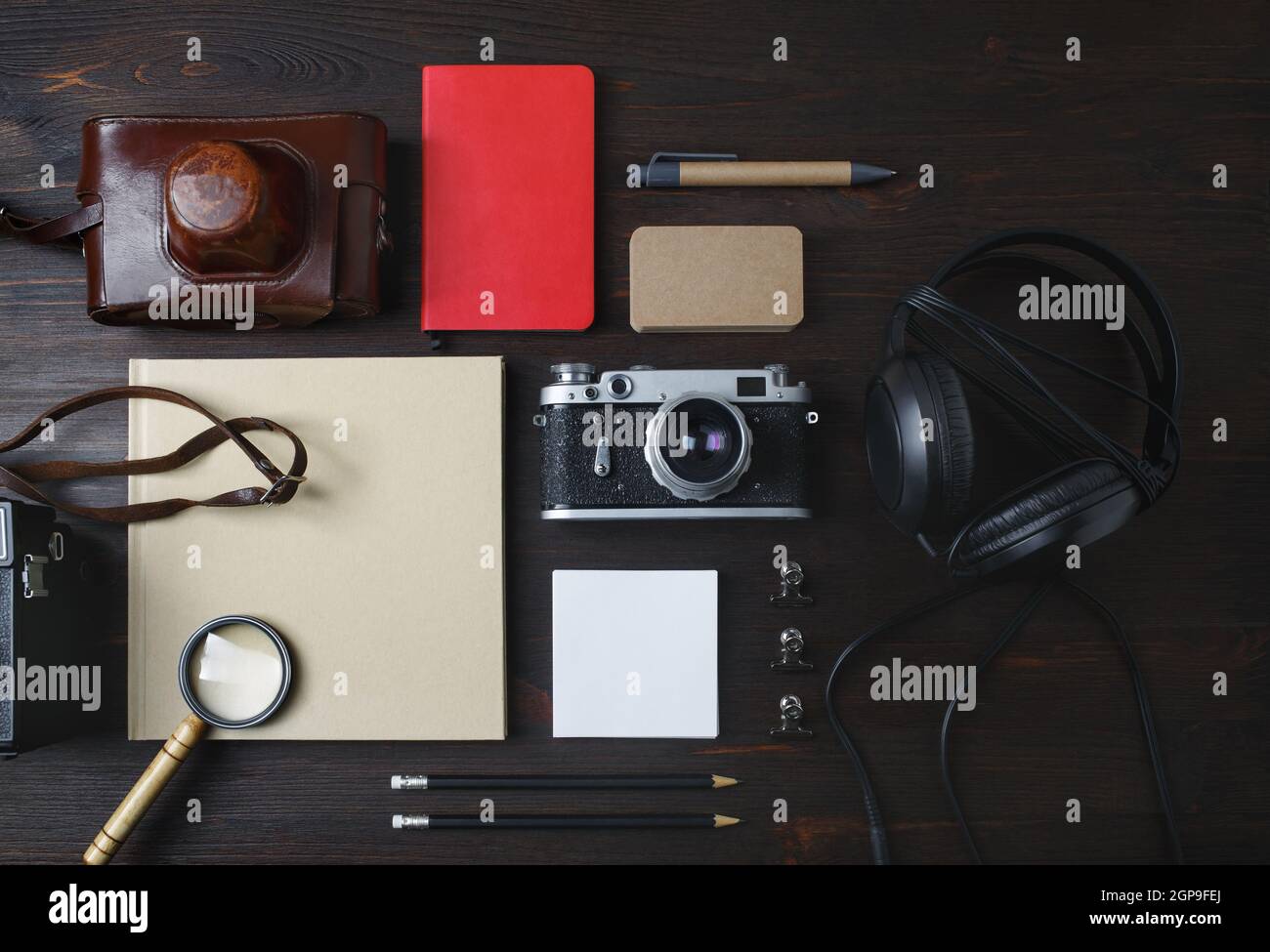 Oggetti da viaggio vintage. Foto di cancelleria vuota e fotocamera retrò su sfondo di legno. Disposizione piatta. Foto Stock