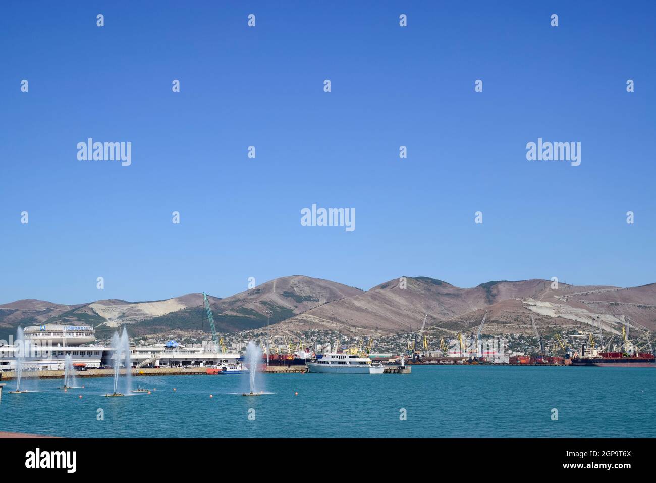 Novorossiysk, Russia - 9 Settembre 2016: porti marittimi internazionali. La porta di carico con gru portuali. Baia Mare e costa di montagna. Foto Stock