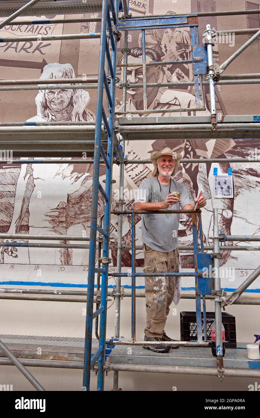 Artista murale Art Mortimer che lavora al restauro del suo murale al Briga di Brandelli su Abbot Kinney Blvd. A Venice Beach, CA Foto Stock