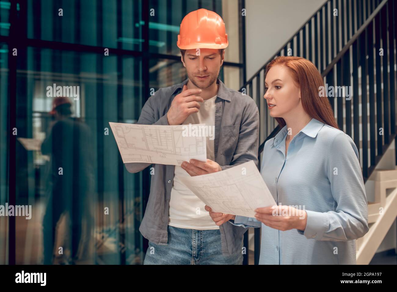 Due giovani dipendenti che discutono del piano di costruzione Foto Stock