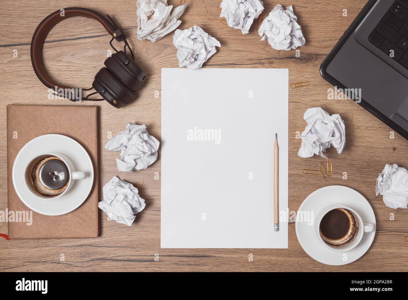 Carta sminuzzata sparsa, tazze vuote di caffè sul tavolo di un lavoratore creativo. Crisi creativa. Concetto di stress, problemi di salute mentale e mancanza di me Foto Stock