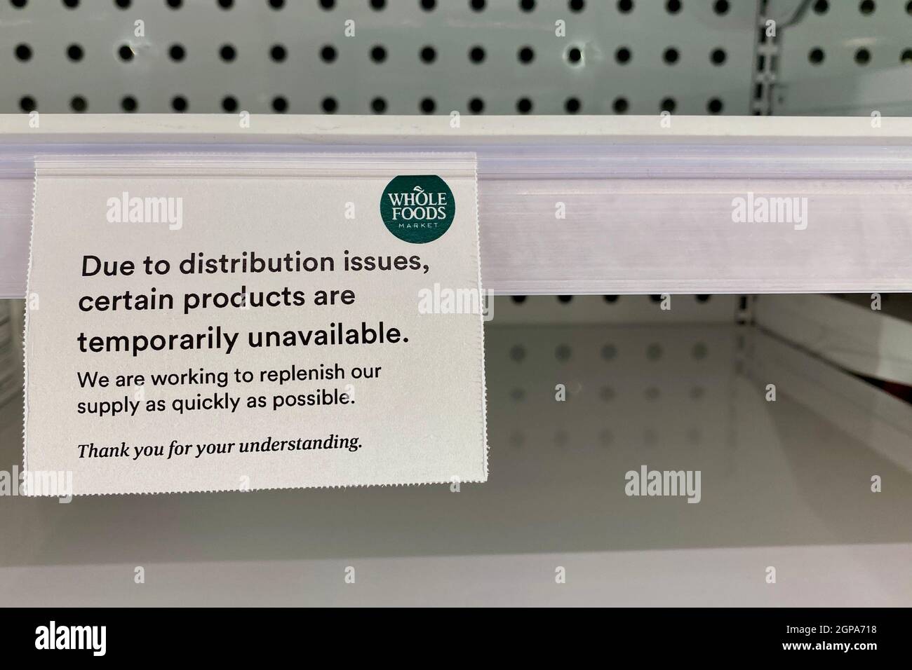 Segnaletica sullo scaffale presso Whole Foods indicante che alcuni prodotti sono temporaneamente non disponibili a causa di problemi di distribuzione. Foto Stock