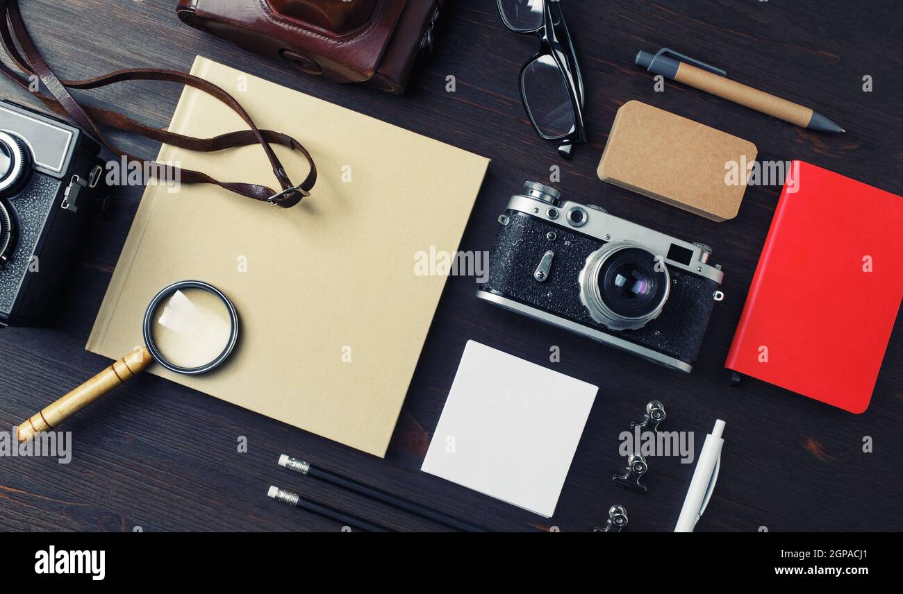 Concetto di viaggio d'epoca. Cancelleria con macchina fotografica su sfondo di legno. Vista dall'alto. Disposizione piatta. Foto Stock