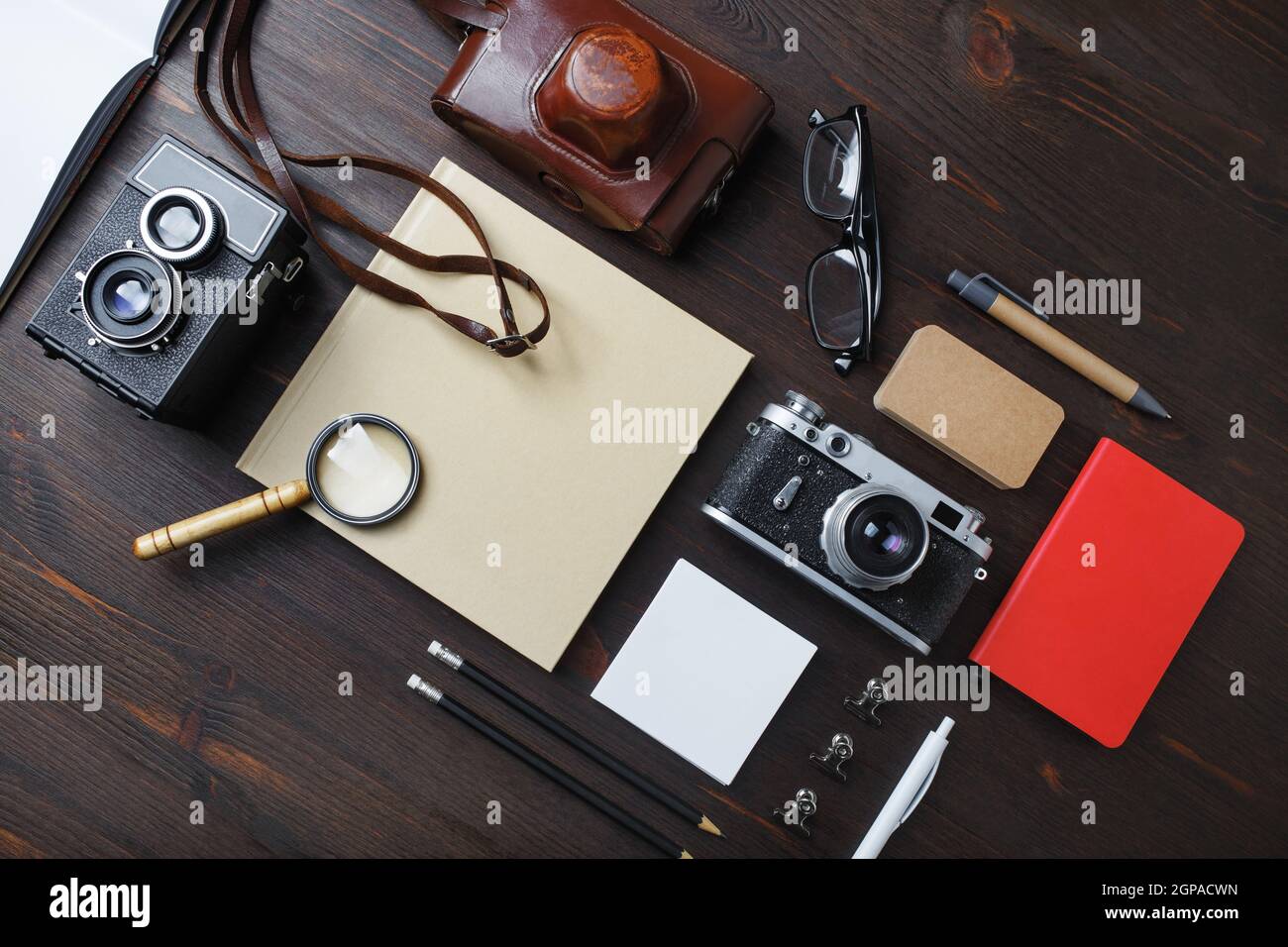 Vita morta retrò. Vecchia macchina fotografica e cancelleria vintage su sfondo tavola di legno. Disposizione piatta. Foto Stock