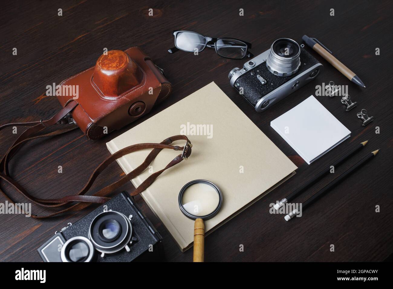 Viaggio di pianificazione con fotocamera retrò e cancelleria vintage su sfondo di legno. Concetto di viaggio o vacanza. Foto Stock