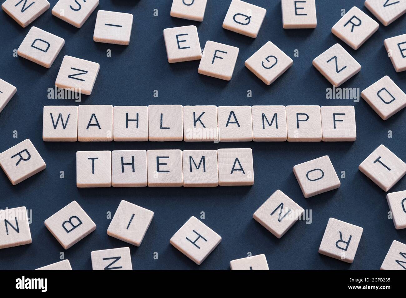 "Wahlkampfthema" è un termine tedesco usato nella politica e nei mezzi di comunicazione. Parola e lettere su sfondo blu. Germania Foto Stock