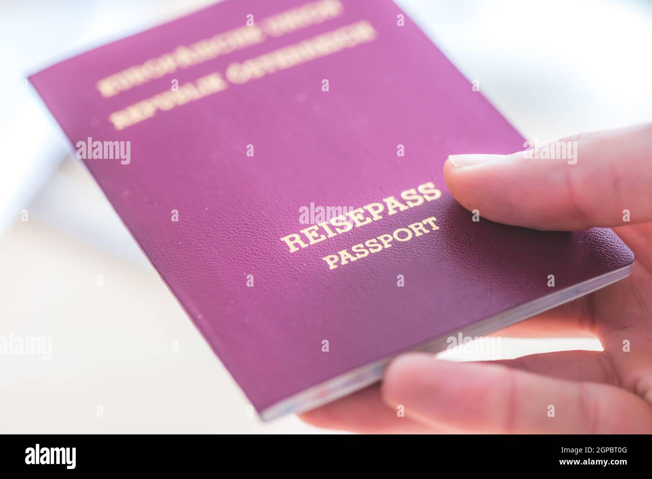 Primo piano con le dita in possesso di un passaporto per viaggiare, aeroporto, "Reisepass Passport" Foto Stock