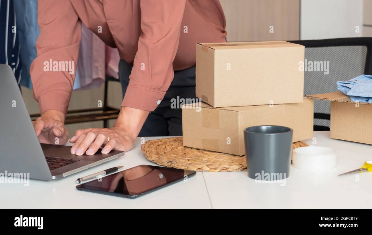 I commercianti in linea dell'imprenditore di piccola impresa che lavorano al deposito che preparano i prodotti per trasportare ai clienti, all'avviamento ed al concetto in linea di affari Foto Stock