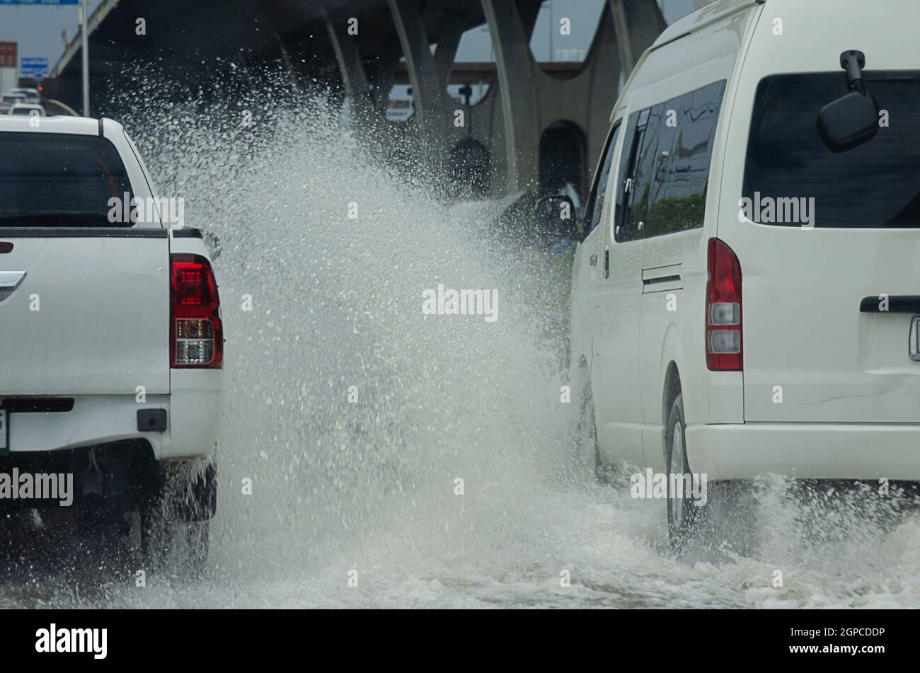 La pioggia battente allaga le strade della Thailandia. L'auto passa attraverso l'acqua allagata. Foto Stock