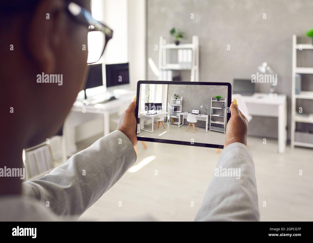 Donna che scatta foto o video dello spazio di lavoro interno in ufficio o appartamento in affitto Foto Stock