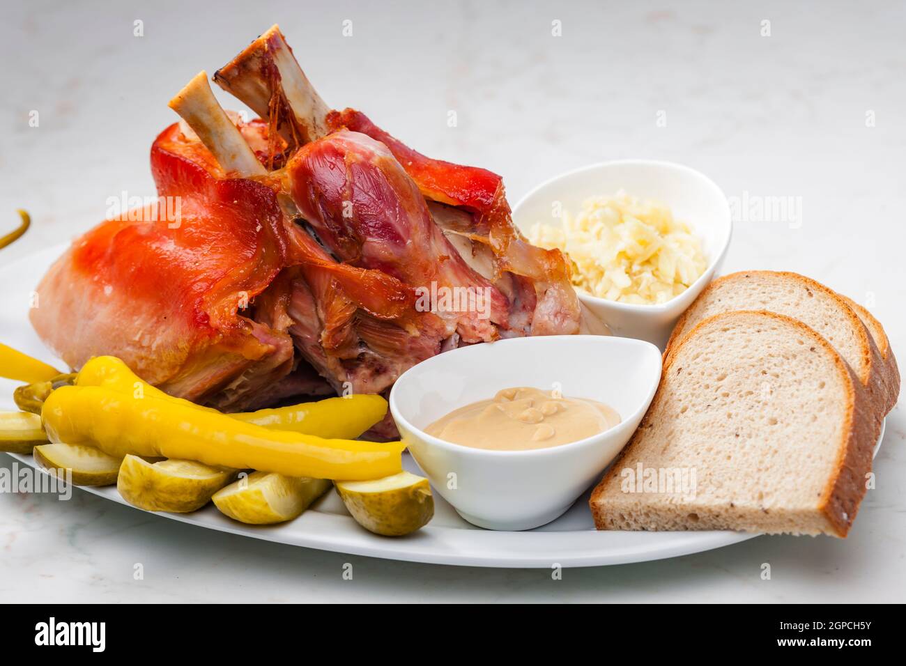 ginocchio di maiale arrosto con verdure raccolte, pane e senape Foto Stock