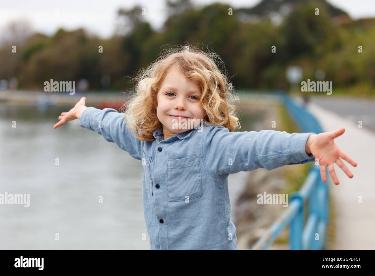 Felice piccolo bambino con lunghi capelli biondi godendo le vacanze Foto Stock